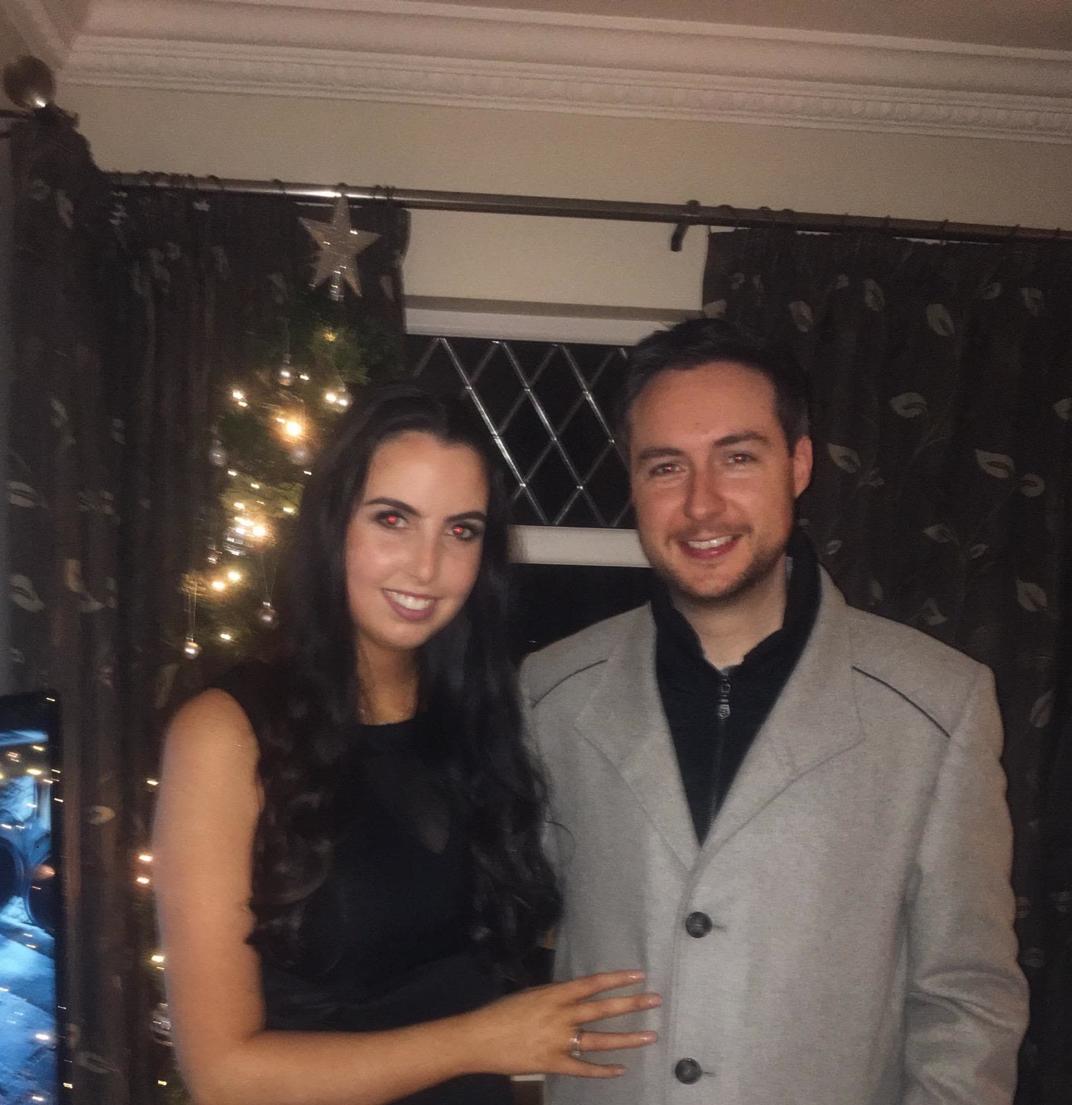 Orlaith showing the engagement ring by the Christmas tree