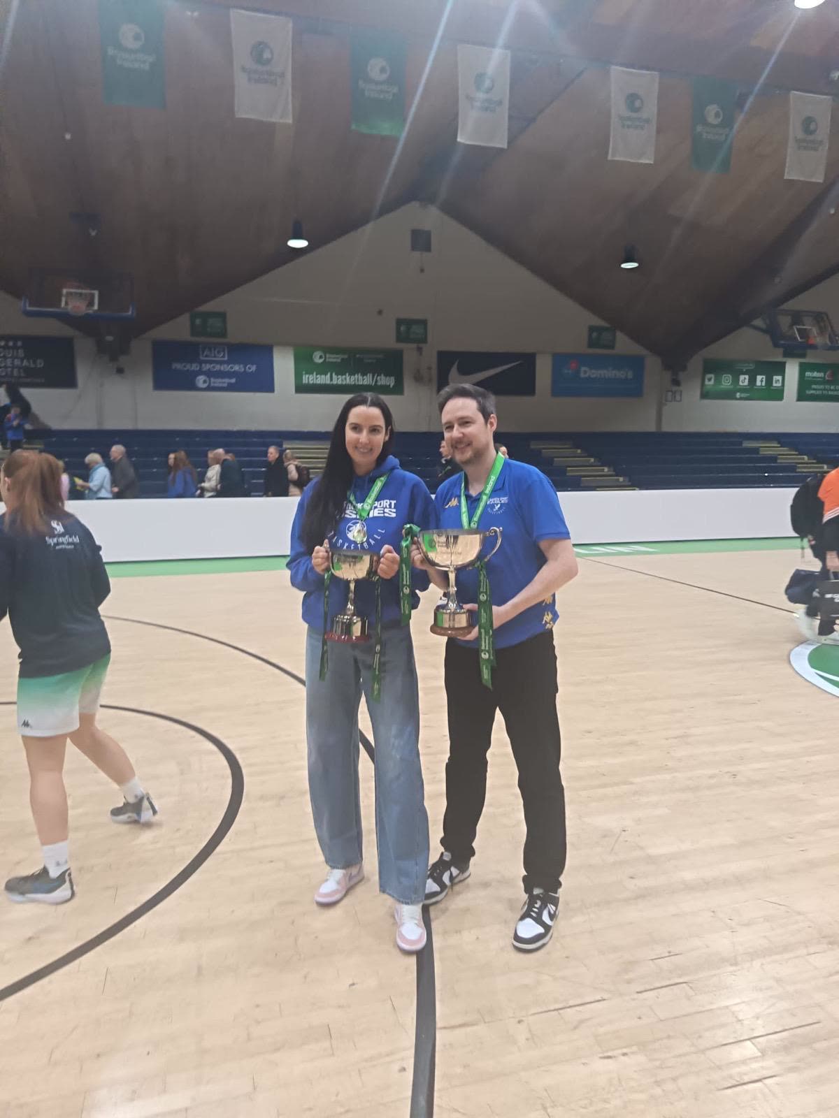 Orlaith and Niall on court, each holding a National Cup